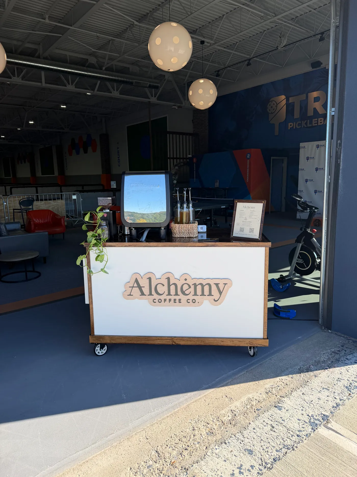 The Alchemy Coffee Co. cart set up for a private booking inside an event venue, infused honeys on the counter