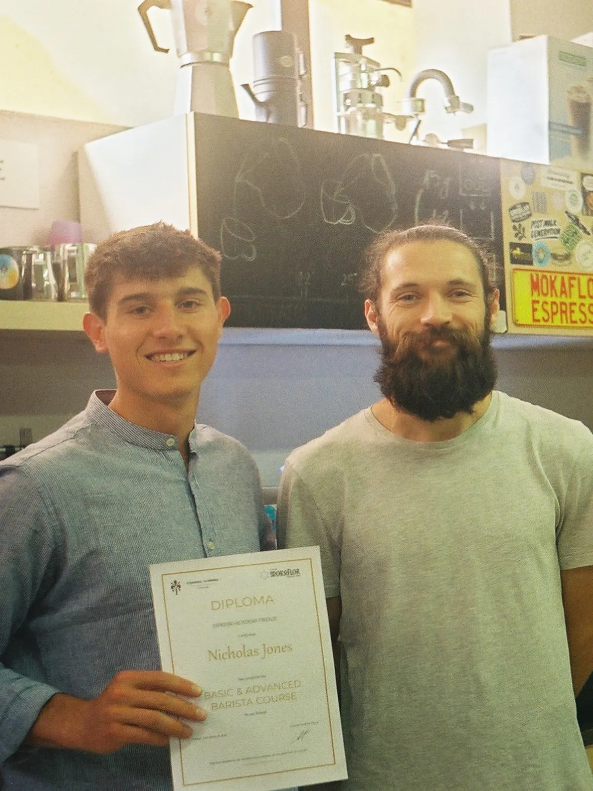 Nicholas Jones holding his barista diploma beside his instructor at Espresso Academy in Florence